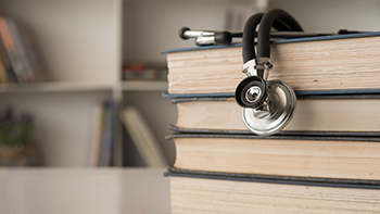 Stethoscope laying on stack of books