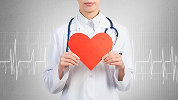 Doctor holding cutout of heart